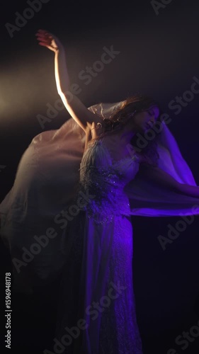A beautiful young woman in a white dress dances in a haze with a mysterious light from behind, beauty fashion and a mystical mood, cinematic light, semi-darkness and rays of light outline the figure