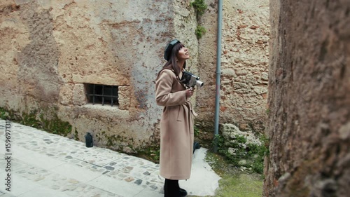 Woman With A Vintage Camera Looking Around The Old Town Streets For Inspiration