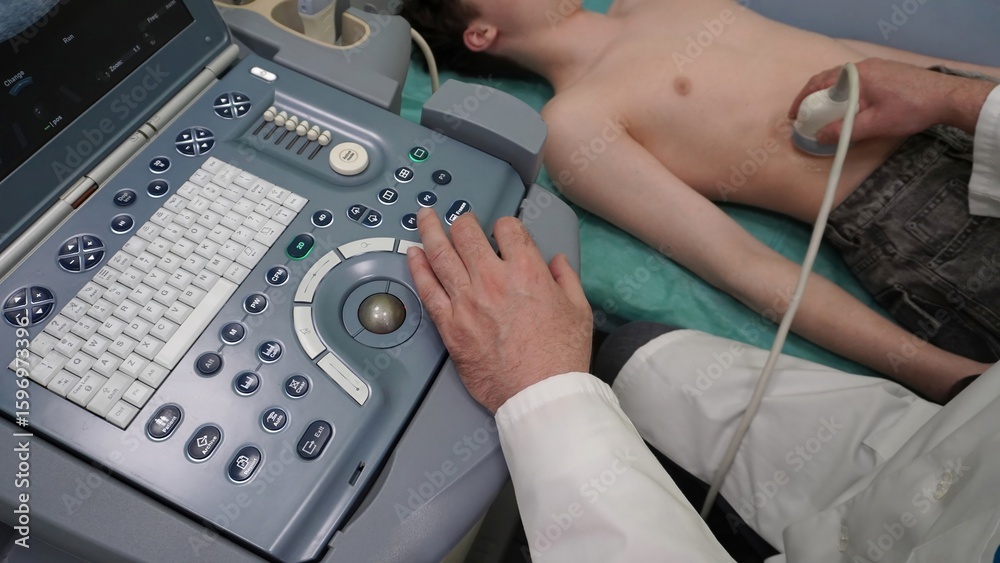 Fototapeta premium Ultrasound examination of the patient. The doctor performs ultrasound diagnostics of the thoracic or abdominal organs in a small patient using a modern ultrasound machine. Doctor's appointment.