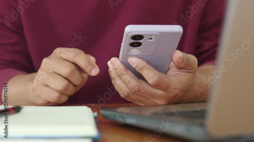 Closeup view of a young caucasian man hand using a smartphone online to check social media and make internet payments. Modern adult male typing texting scrolling on mobile phone at home.