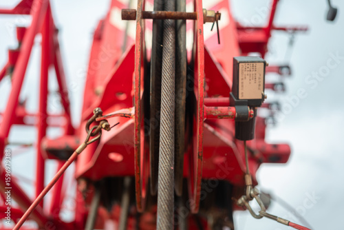 Wire rope sling and sheave wheel main hook, hoisting system of construction crane machine. Industrial and transporation equipment, close-up with selective focus.