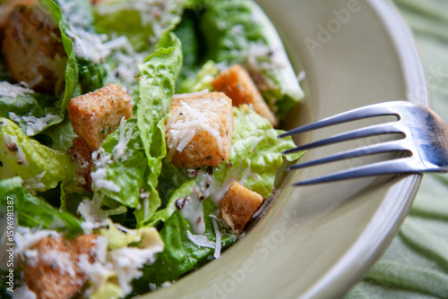 Fotografija Close-up image of a Caesar salad featuring crisp romaine lettuce, crunchy seasoned croutons, freshly grated Parmesan cheese, and creamy Caesar dressing