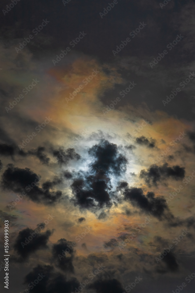 Fototapeta premium Sun shines through high clouds and creates dramatically brilliant multicolored halo