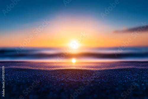 Serene sunset over ocean, with gentle waves reflecting warm colors
