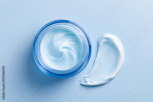 Moisturizing face cream in blue jar on pastel background