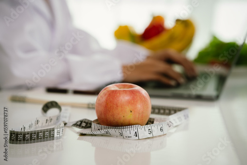 A professional dietitian consults with patients online, discussing nutrition, weight loss, and healthy eating habits using a laptop in a clinic setting.