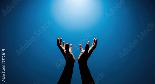 Hands reaching up toward a bright light against a blue gradient background evoke themes of hope, faith, and spirituality, suitable for inspirational or religious content.