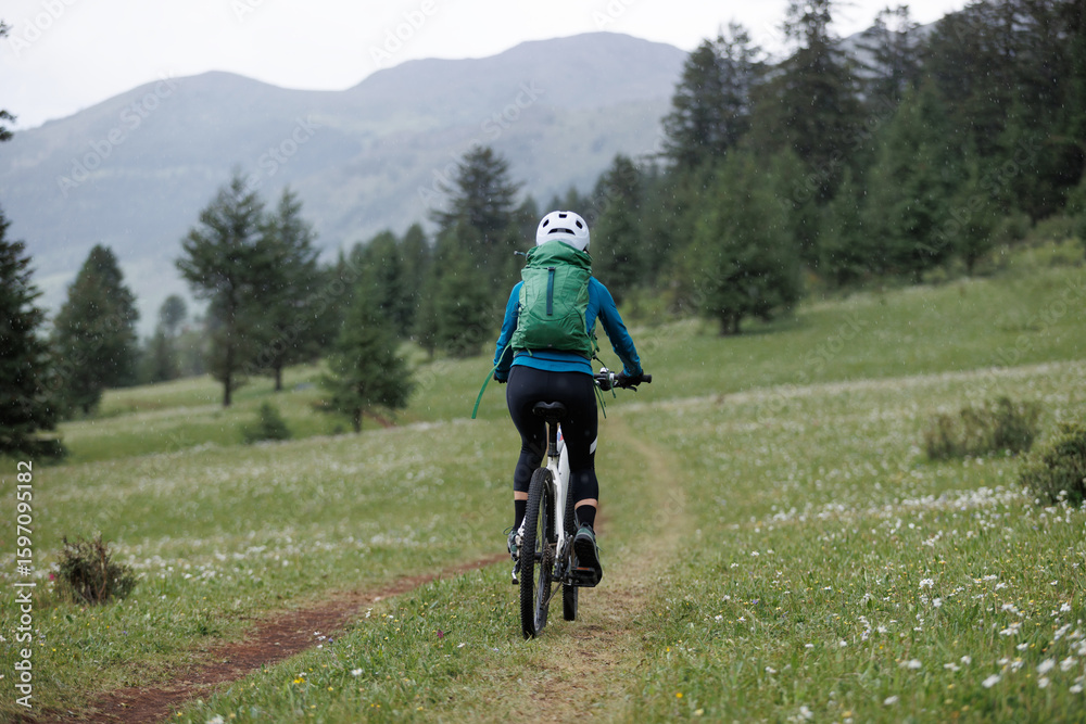Fototapeta premium Riding mountain bike on grassland forest mountains