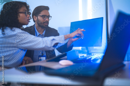 Obraz na plátně Two diverse software developers celebrate a breakthrough, happily discussing a successful project
