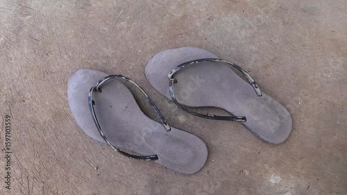 a pair of worn black sandals