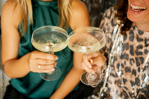 Two women celebrating, holding champagne glasses at a party