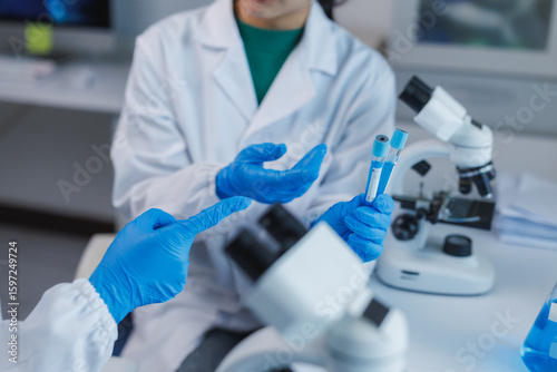 Scientists discussing test tubes in laboratory research