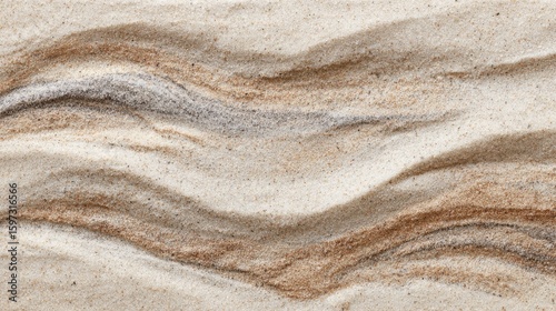Smooth, wavy textures of sand reveal a natural artistry, blending earthy tones in a beach setting. Sunlight enhances the intricate patterns, evoking a sense of calm.