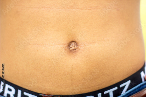 A handsome young man shows his naked body and navel