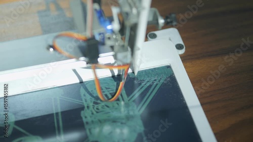 Tablet with a stylus on it. The tablet is displaying a drawing of a city. The drawing is of a futuristic city with tall buildings and a lot of technology. Scene is one of innovation and progress