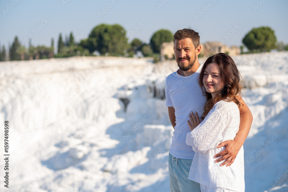 Couple Enjoying the Stunning Thermal Pools of Pamukkale in Turkey on a Sunny Day Amidst White Travertine Terraces Couple Enjoying the Stunning Thermal Pools of Pamukkale in Turkey on a Sunny Day Amidst White Travertine Terraces