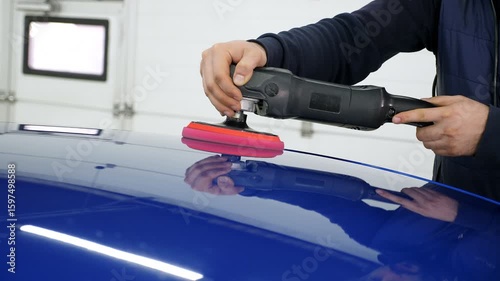 Wallpaper Mural A man polishes a blue car with a car polishing machine at a car dealership. Car detailing and polishing concept.  Torontodigital.ca