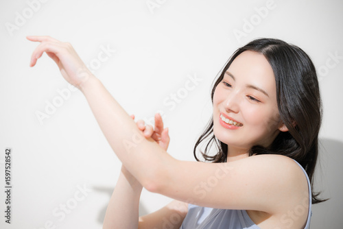 Tableau sur toile 日焼け止めを塗るかわいい女性　腕に日焼け止めなどを塗る　夏の日差しと暑さ対策