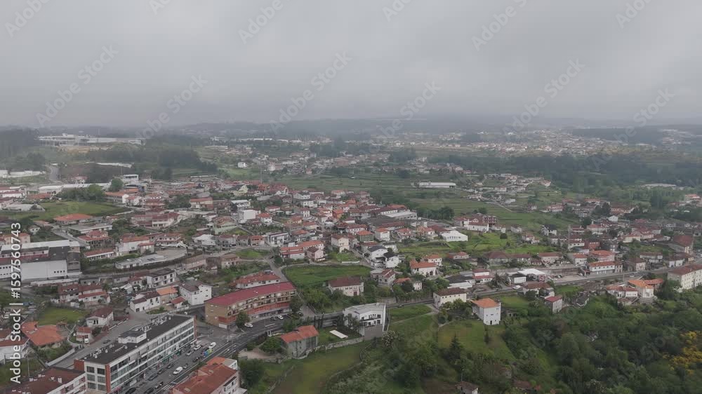 aerial wide view of Vila das Aves Portugal under overcast sky with scattered houses and fields aerial wide view of Vila das Aves Portugal under overcast sky with scattered houses and fields