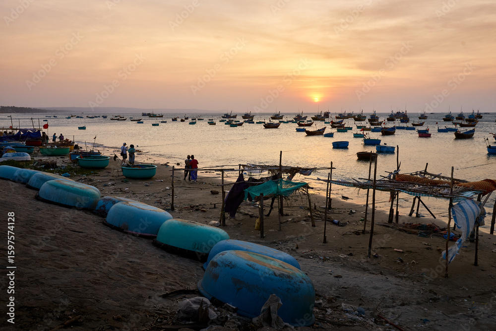 Numerous traditional fishing boats line the sandy shore of a coastal village at sunset, creating a vibrant and authentic scene of local life and maritime culture. Numerous traditional fishing boats line the sandy shore of a coastal village at sunset, creating a vibrant and authentic scene of local life and maritime culture.