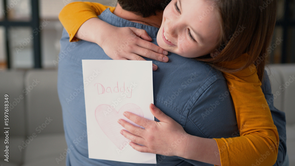 Happy family carefree Caucasian girl daughter embracing dad male man parent at home inside dad father little schoolgirl preteen kid hug touch daddy guy smile kid hold present card celebration holiday Happy family carefree Caucasian girl daughter embracing dad male man parent at home inside dad father little schoolgirl preteen kid hug touch daddy guy smile kid hold present card celebration holiday