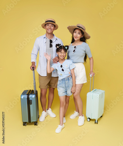 happy Asian family of three including a father mother and daughter dressed in summer attire ready for fun vacation with their luggage.
