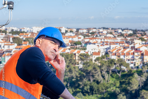 Portrait of an engineer wearing protective workwear posing looking at an unspecified point leaning chin on hand