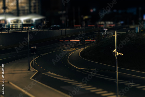 Night highway with barriers, entrance to the territory, tilt shift effect