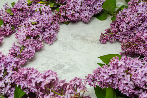 Spring feminine scene, floral composition. Decorative banner, corner made of beautiful purple lilac flowers. White table background.