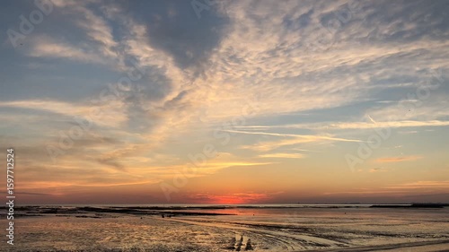 Time-lapse of a sunset over a beach at low tide near La Rochelle in France 