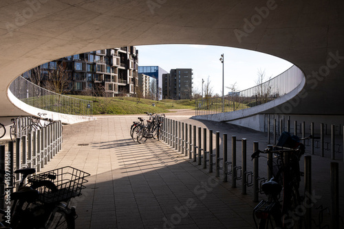 Circular ceiling opening with bicycle parking and new residential buildings in Copenhagen, Denmark, highlighting integration of soft mobility and urban ecological design systems