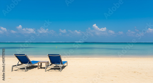 Beach with palm trees and sun loungers by ocean