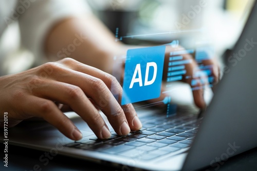 Close up of hands typing on a laptop keyboard with a digital advertisement icon overlayed representing online marketing and digital strategy
