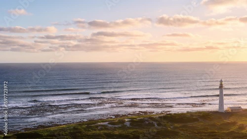 Lighthouse on Coastal Cliff at Ocean Sunset