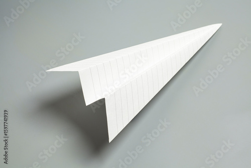 Origami paper airplane on gray background