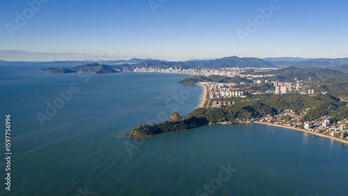 Aerial view of Praia Brava in Itajaí with Balneário Camboriú skyline in the background on a sunny day.