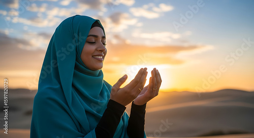 Woman in hijab praying at sunset with hands raised in supplication and serene expression