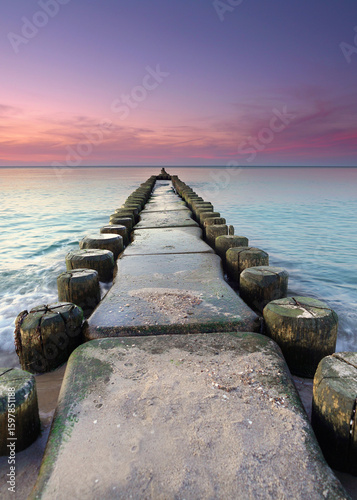 Foto Autumn Sunset Over the Baltic Sea with a Weathered Wooden Groyne and Peaceful Be