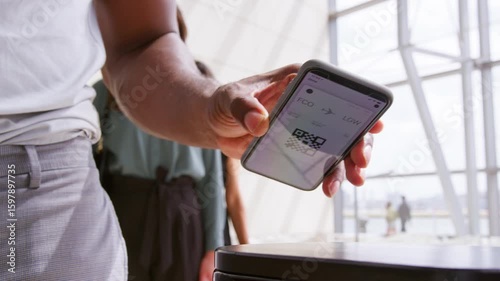 Close up of business passengers in airport departure lounge scanning digital boarding pass on smart phone  - shot in slow motion 