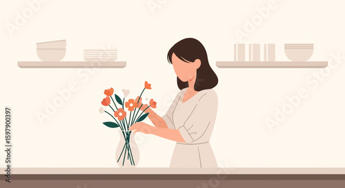 Young Woman Arranging Flowers In Vase On Kitchen Counter With Modern Interior