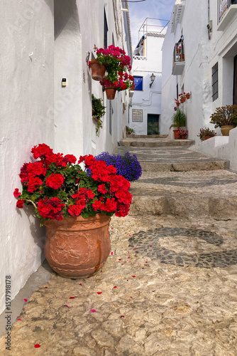 FRIGILIANA, SPAIN - MAY 10, 2025: A peaceful walk through the charming narrow streets, surrounded by whitewashed houses and colorful flowers in Frigiliana, Spain