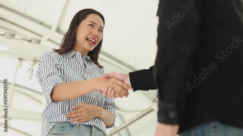 Slow motion two business people stand outside the building being handshaking for partnership after meeting and business accomplishment. Introduction for thank you, welcome or greeting concept