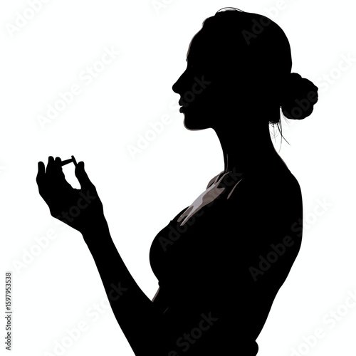 Silhouetted woman holds ring, facing left, under bright illumination. Silhouette captures jewelry detail as woman examines band, and thoughtfully studies its shape. Use silhouette for jewelry ad.