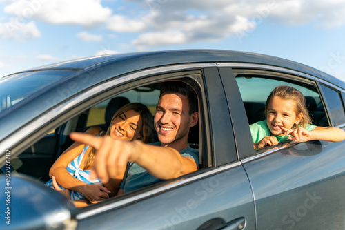 Φωτογραφία The family is sitting in the car, stepfather is showing his stepdaughter and his