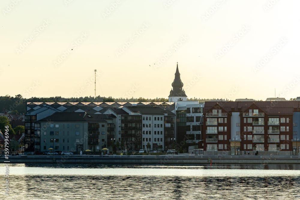 Fototapeta premium Hudikskvall, Sweden JA sunset skyline silhouetted view of the city and the Baltic Sea seafront.