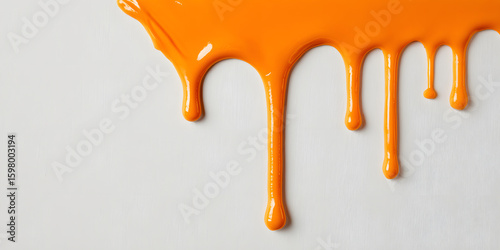 A thick glob of orange slime hanging from the edge of a white surface, uneven shape, solo substance