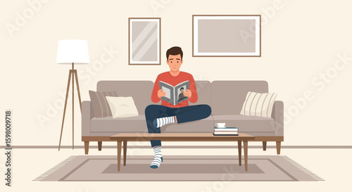 Young Man Relaxes At Home Enjoying A Good Book On A Sofa In The Living Room