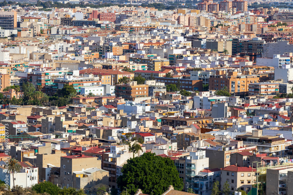 Aerial view of densely packed residential buildings in Alicante, Spain. The vibrant urban landscape showcases a mix of architecture, reflecting both modern and traditional styles. Aerial view of densely packed residential buildings in Alicante, Spain. The vibrant urban landscape showcases a mix of architecture, reflecting both modern and traditional styles.