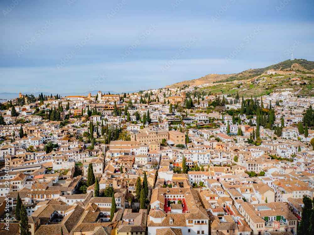 Fototapeta premium Panoramic sunrise over Albaicín in Granada, Spain, with whitewashed houses, narrow streets, and rolling hills—capturing the charm of Andalusian heritage and Mediterranean travel.