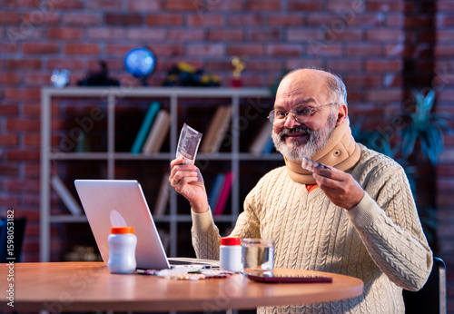 Senior Indian man finds discount on medicine via online shopping at home